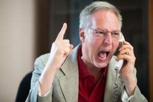 Portrait of an angry businessman yelling at phone