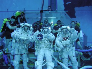 Szkolenie astronautów NASA - JSC2005-E-14733 (21 March 2005) —Three STS-114 astronauts give a simultaneous thumbs-up signal to indicate preparedness during an underwater training session in the Neutral Buoyancy Laboratory in Houston. From the left are Soichi Noguchi of JAXA, Stephen K. Robinson and Andrew S.W. Thomas. A number of SCUBA-equipped divers participated in the dive to assist the astronauts. Noguchi and Robinson have been in training for a lengthy period of time, preparing for three scheduled spacewalks on the first flight marking return to space following the Columbia mission of 2003. Thomas, working inside the Space Shuttle Discovery’s cabin, will serve as the lead robotics officer for the inspection of the Orbiter’s thermal protection system using a new boom extension outfitted with sensors and cameras. He will also serve as the Intravehicular Activity crewmember helping to suit up and choreograph spacewalkers Noguchi and Robinson for their spacewalks. Image by NASA and in public domain. Thanks, NASA!